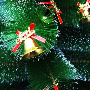Golden Merry Christmas bells with red ribbon bows on green pine branches