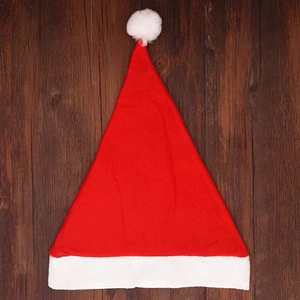 Classic red Christmas hat with white plush trim on a dark brown wood background