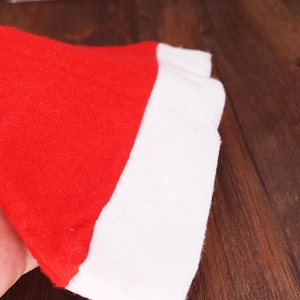 Classic red and white non-woven Christmas hat shown on dark wood texture background