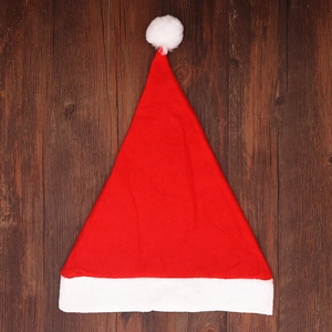 Detailed view of a classic red and white Christmas hat on a rustic dark wood background