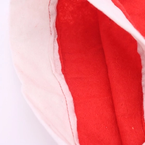 Macro detail of red and white non-woven fabric with reinforced stitching on Christmas hat