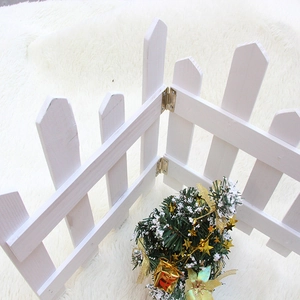 Close-up of white wooden mini fence with golden metal hinges for Christmas decor