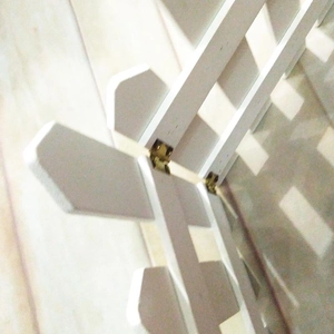 Detail of golden metal hinges on a white foldable wooden fence for garden decor