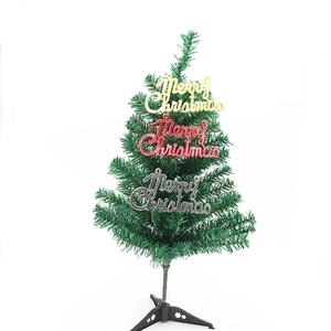 Golden, red and silver Merry Christmas letter plates on a small green Xmas tree