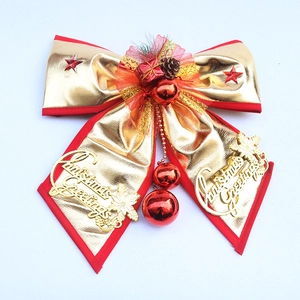 Large gold Christmas bow with pine cones, red gift boxes and Merry Christmas lettering