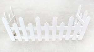 Detail of white picket wooden fence showing U-shape garden edging and pointed top design