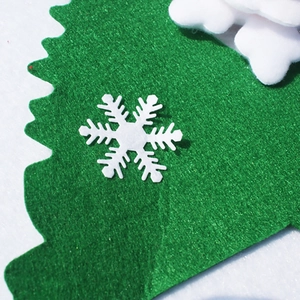 Close-up of green felt Christmas banner with soft fiber texture and white snowflake detail