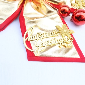 Detail of a Christmas bow with gold metallic fabric and Christmas Greetings lettering
