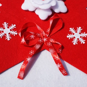 Close-up of red felt Christmas banner with white snowflake patterns and decorative bow