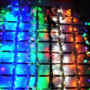 Detailaufnahme der 10m bunten LED-Lichterkette, die an einer weißen Gitterwand hängt