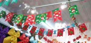 Detail of red and green Merry Christmas banners hanging indoors with Santa Claus motifs
