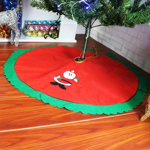 Detail of red and green felt Christmas tree skirt with cute Santa Claus applique embroidery