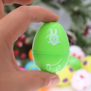 Green plastic Easter egg with white rabbit pattern held in hand for festival decoration