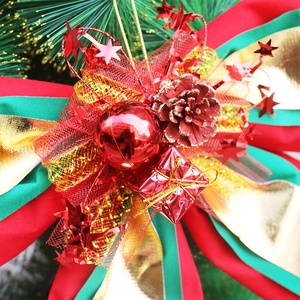 Detail of red and green Christmas bow with pine cones and golden mesh for tree decor