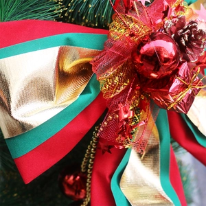 Large red and green Christmas bow with gold trim and festive pine cone ornaments