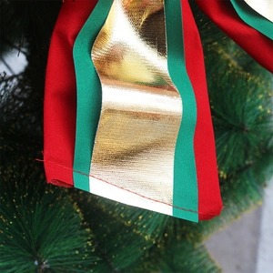 Large Christmas bow decoration in red, green and gold on a festive holiday tree