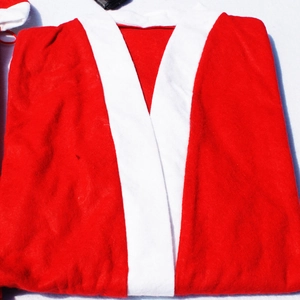 Détail du costume de Noël rouge plié avec col en peluche blanc et texture du tissu
