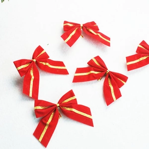 Close-up of five 5cm red fabric Christmas bows with gold stripes and pine needle accents