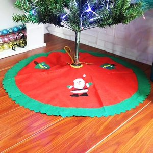 Detail of red Christmas tree skirt with Santa Claus applique and green scalloped edge