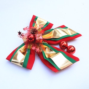 Large red and green Christmas bow ornament with gold accents and festive baubles