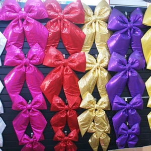 Close-up of glitter fabric Christmas bows in vibrant metallic colors on display hooks