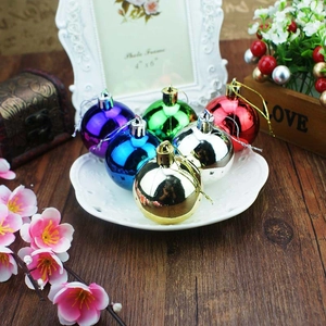 Mirror finish Christmas tree ornaments in six assorted colors displayed on a ceramic plate