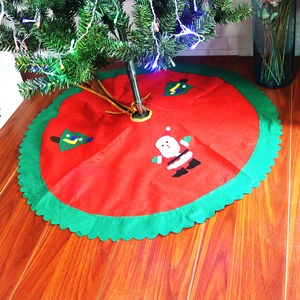 Detailed view of red Christmas tree skirt with Santa Claus applique and gold ties