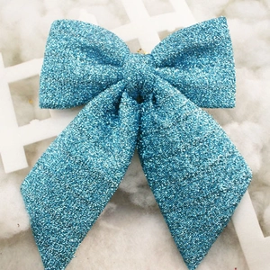 Close-up of sparkling blue glitter bow with metallic loop for Christmas tree decor
