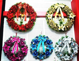 Detailed view of 60cm Christmas wreaths with bows and Merry Christmas signs in various colors