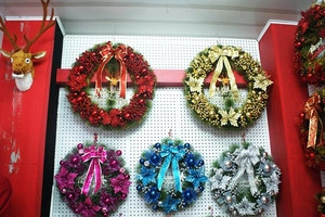 Close-up of assorted colorful 60cm Christmas wreaths with large bows and festive ornaments