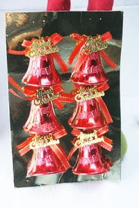 Detail von roten Weihnachtsglocken mit goldenen Schleifen und Merry Christmas Text