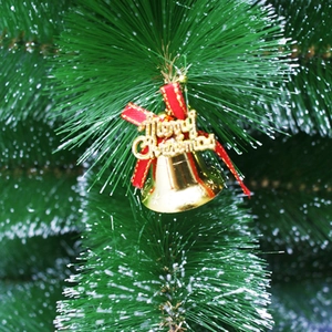 Nahaufnahme goldener Weihnachtsklocken mit roter Schleife an einem grünen Tannenbaumzweig