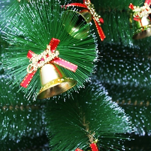 Details von Weihnachtsbaumglocken mit goldenem Merry Christmas Schild und roter Schleife
