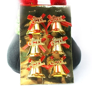 Nahaufnahme goldener Weihnachtsglocken mit roten Schleifen und Merry Christmas Gravur