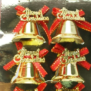 Nahaufnahme von goldenen Weihnachtsklingeln mit roten Schleifen und Schriftzug