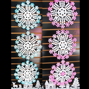 Close-up of pink and blue gradient snowflake hanging decorations for Christmas shop window