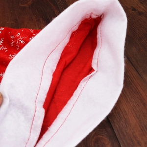 Red velvet Christmas hat with silver snowflake patterns and a white faux fur trim