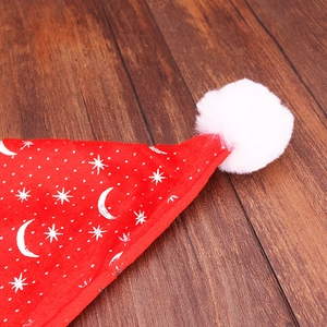 Red velvet Christmas hat with silver stars and moon patterns and a white pompom