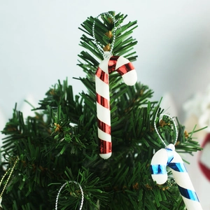 Close-up of red, blue, and silver mini candy cane ornaments hanging on a Christmas tree
