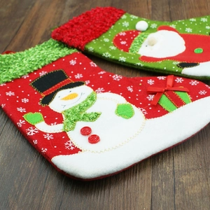 Christmas stockings featuring felt applique Santa Claus and Snowman on wooden floor