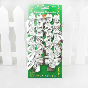Detailed view of 12 silver glitter Christmas bows packaged on a green card for decoration