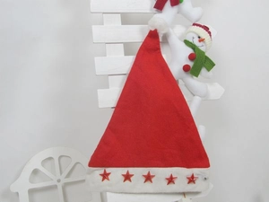 Detail of red Christmas hat with five-star design hanging on a white wooden fence