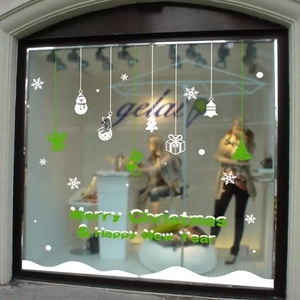 Detail van witte en groene kerst sneeuwvlok raamstickers op een glazen winkeletalage