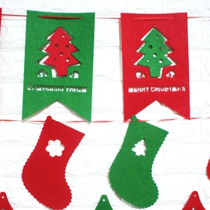 Christmas felt banner set with red and green triangle flags and socks hanging on white wall