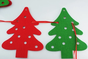 Detail of red and green felt Christmas tree banners with red ribbon on white background