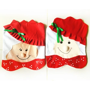 Set of two red Christmas chair covers with festive character faces and white polka dots