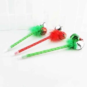 Gros plan des stylos de Noël avec plumes festives, cloches et motifs à pois rouges et verts