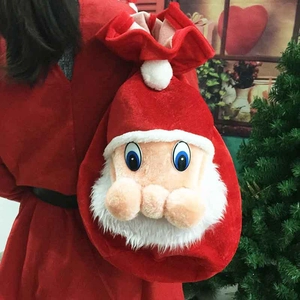 Red velvet Christmas gift bag with a plush Santa face and a white drawstring closure