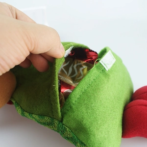 Detail of green felt Christmas candy bag featuring secure white velcro closure design