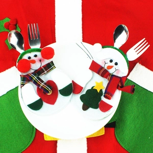 Porta cubiertos navideños de muñeco de nieve con corazón rojo y árbol sobre un plato